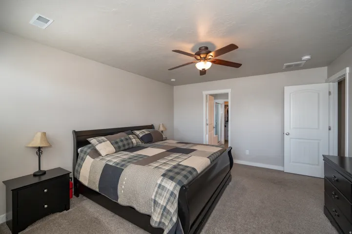 Bedroom featuring dark carpet and a ceiling fan