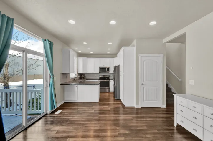 Kitchen featuring white cabinetry, recessed lighting, a peninsula, stainless steel appliances, and dark wood-type flooring