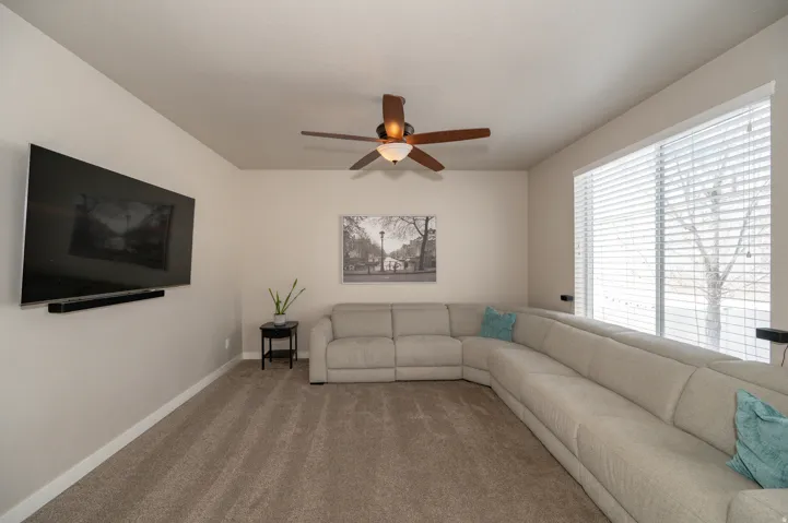 Living room featuring a ceiling fan and carpet floors