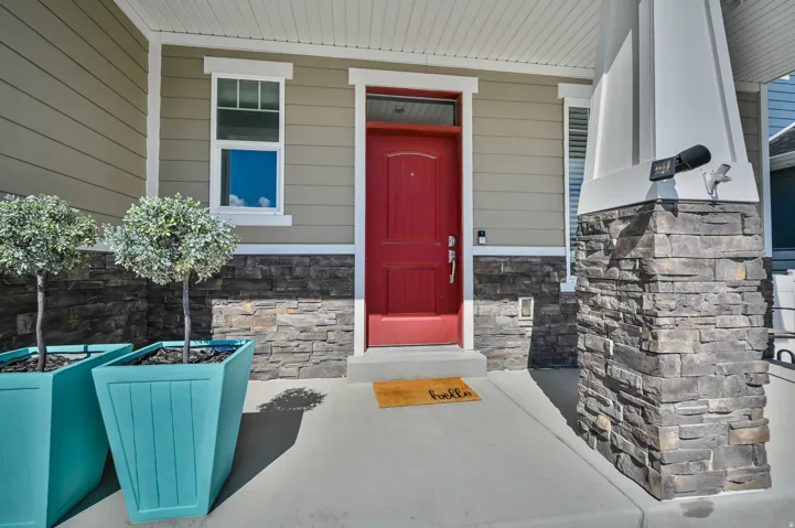 View of exterior entry featuring a porch and stone siding