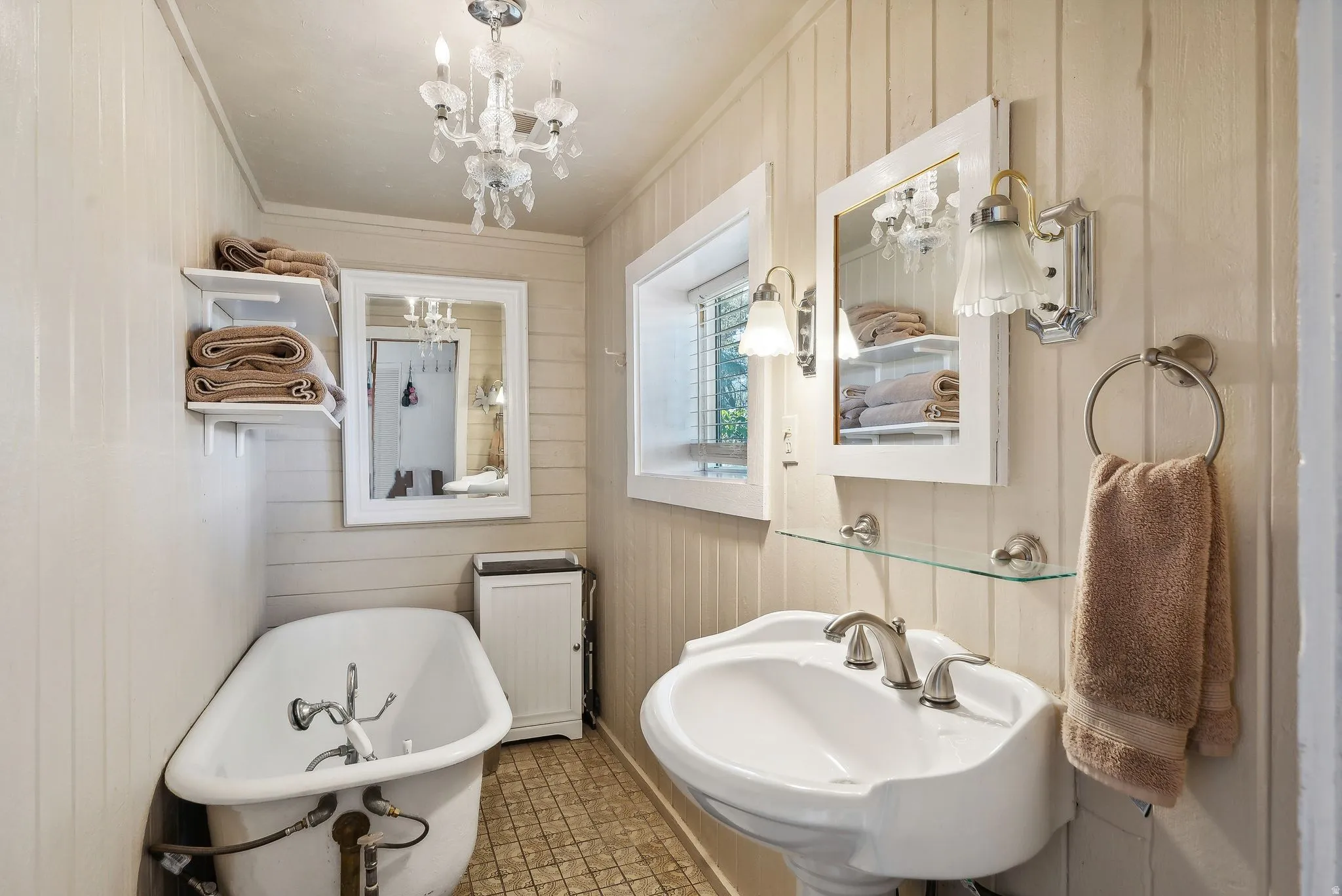 Bathroom with a soaking tub, wooden walls, a chandelier, radiator heating unit, and ornamental molding