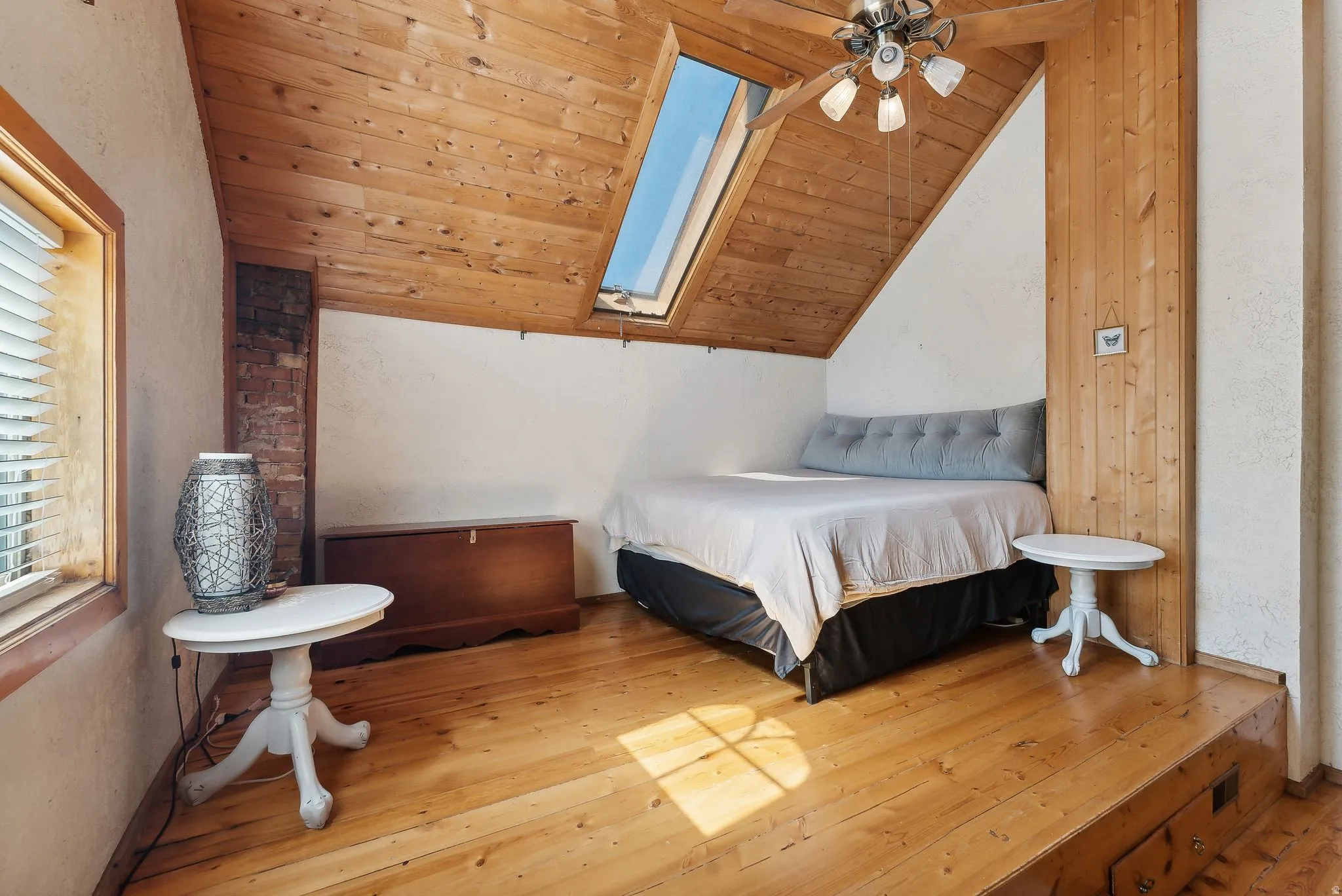 Bedroom featuring a skylight, wood-type flooring, a vaulted wooden ceiling, and ceiling fan