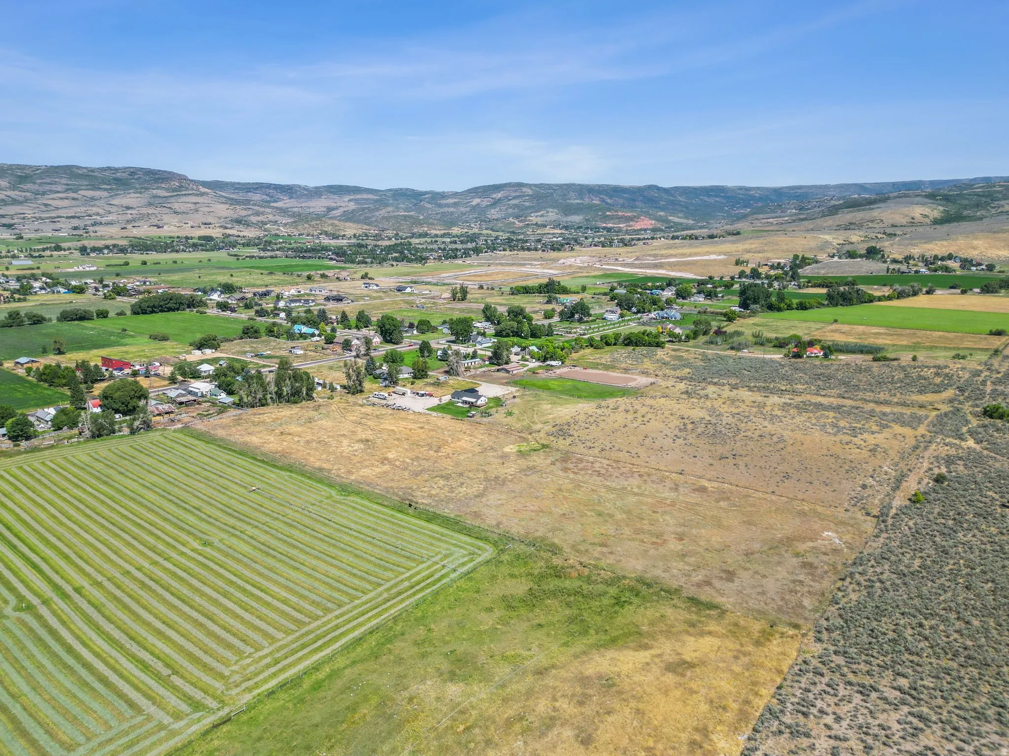 View of rural area with a mountainous background and rows of crops