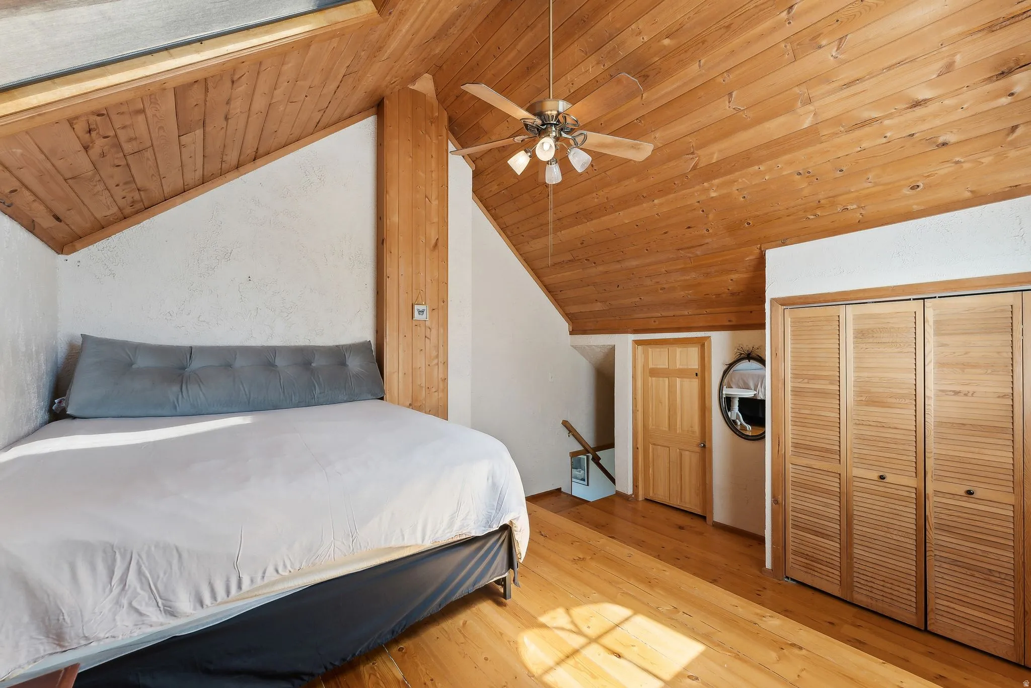 Bedroom with wood-type flooring, ceiling fan, a vaulted wooden ceiling, and a closet