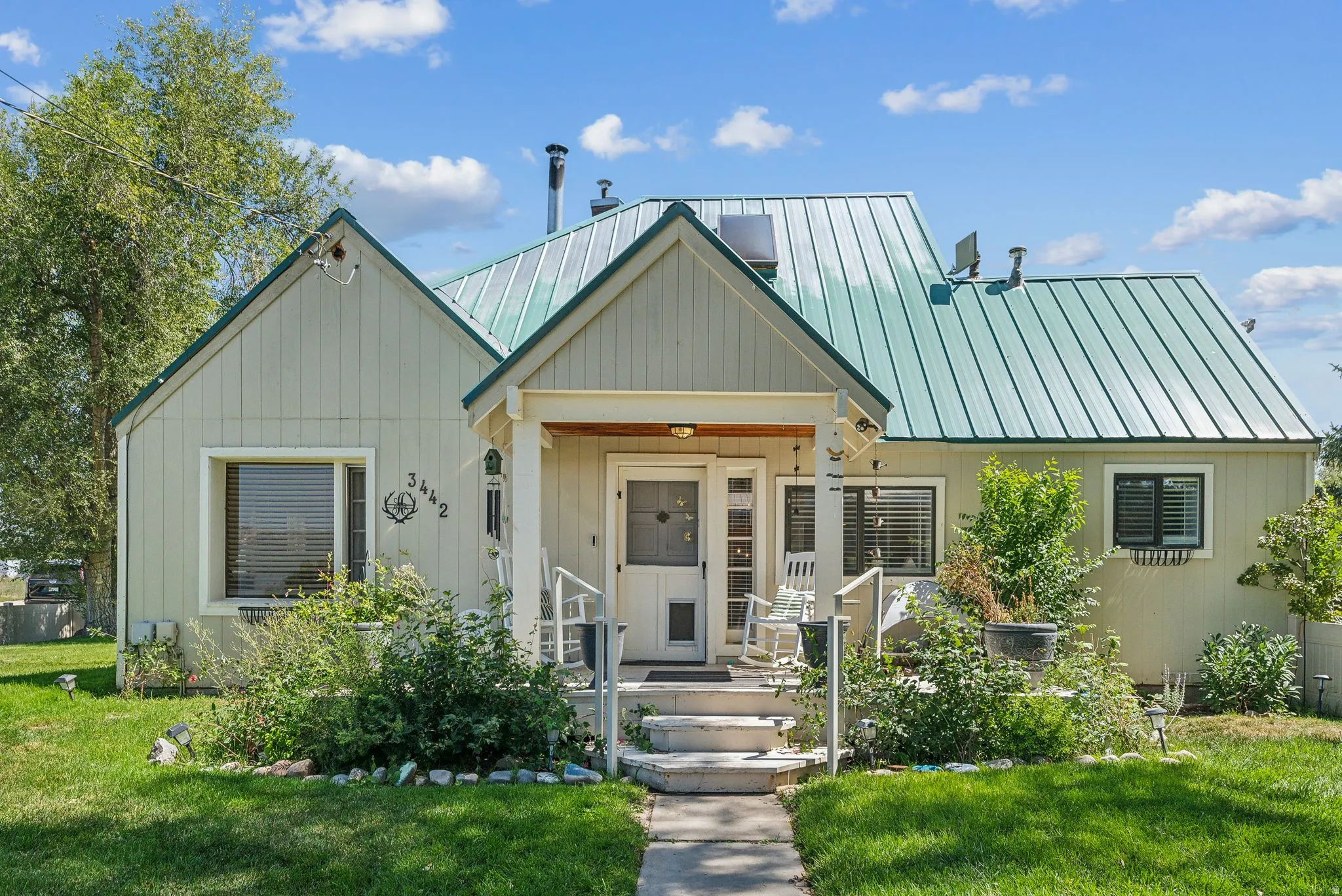 View of front facade with a front lawn and a metal roof