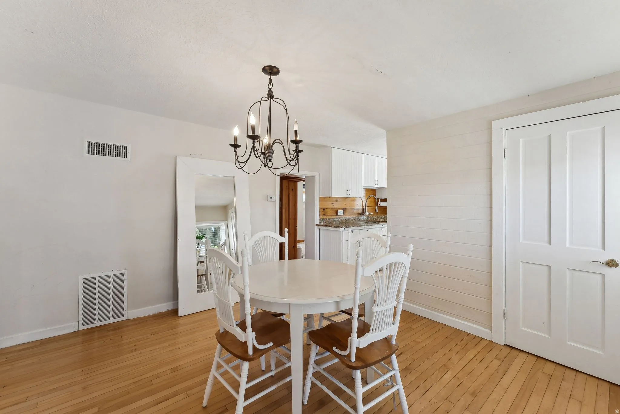 Dining area featuring light wood-style flooring and suspended lighting