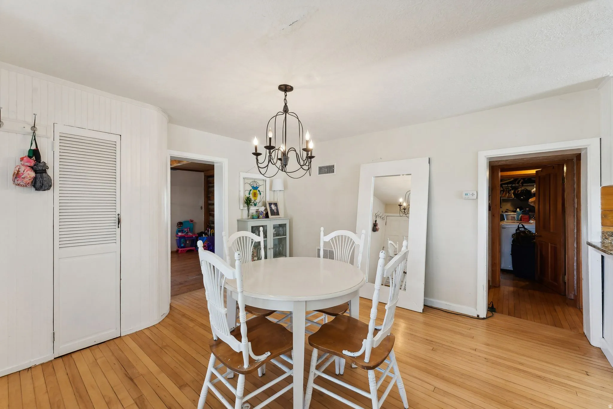 Dining room with hanging lights and light wood finished floors