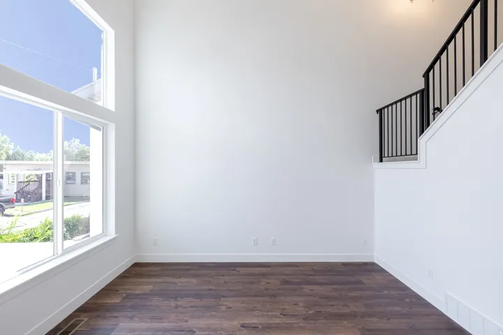 Soaring ceilings complemented by tall windows and wood-finish flooring
