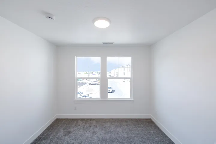 Recessed lighting, two large windows, white trim, and carpeted flooring
