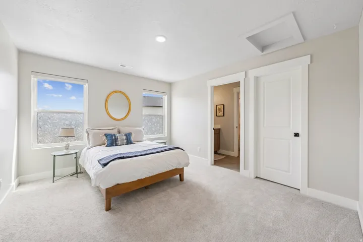 Bedroom with light carpet, connected bathroom, and a textured ceiling