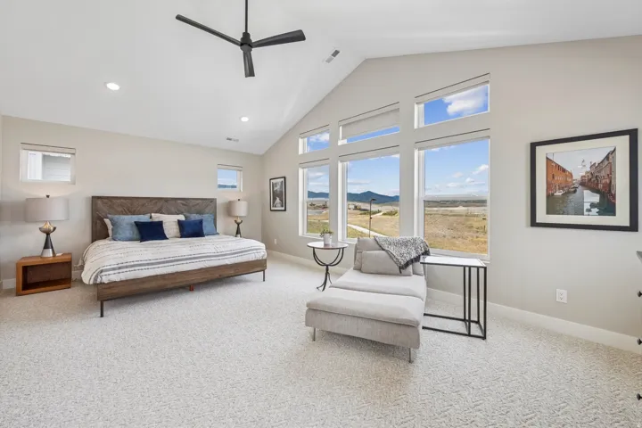 Bedroom featuring a mountain view, a ceiling fan, lofted ceiling, light colored carpet, and recessed lighting