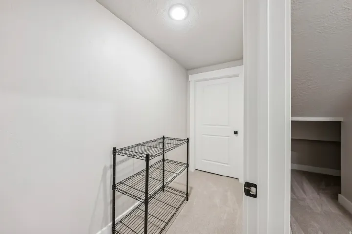 Hall with a textured ceiling and light colored carpet
