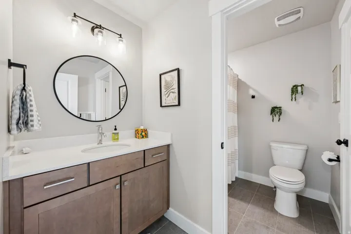 Full bathroom featuring a shower with shower curtain, vanity, and dark tile patterned floors