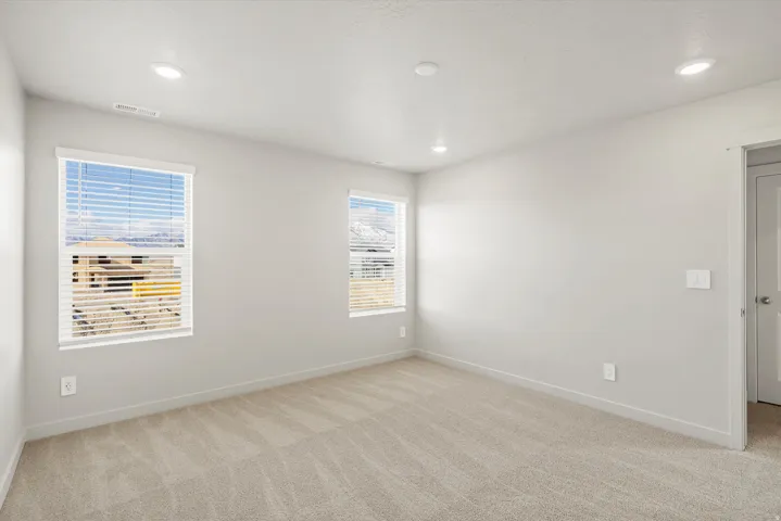 Unfurnished room with light colored carpet and recessed lighting