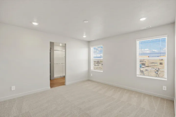 Spare room featuring light colored carpet and recessed lighting