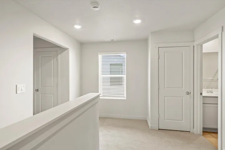 Hall featuring light carpet and recessed lighting