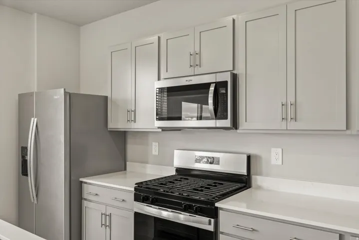 Kitchen featuring stainless steel appliances and light stone counters