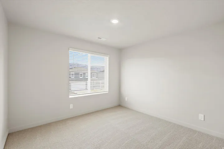 Spare room featuring light carpet and baseboards