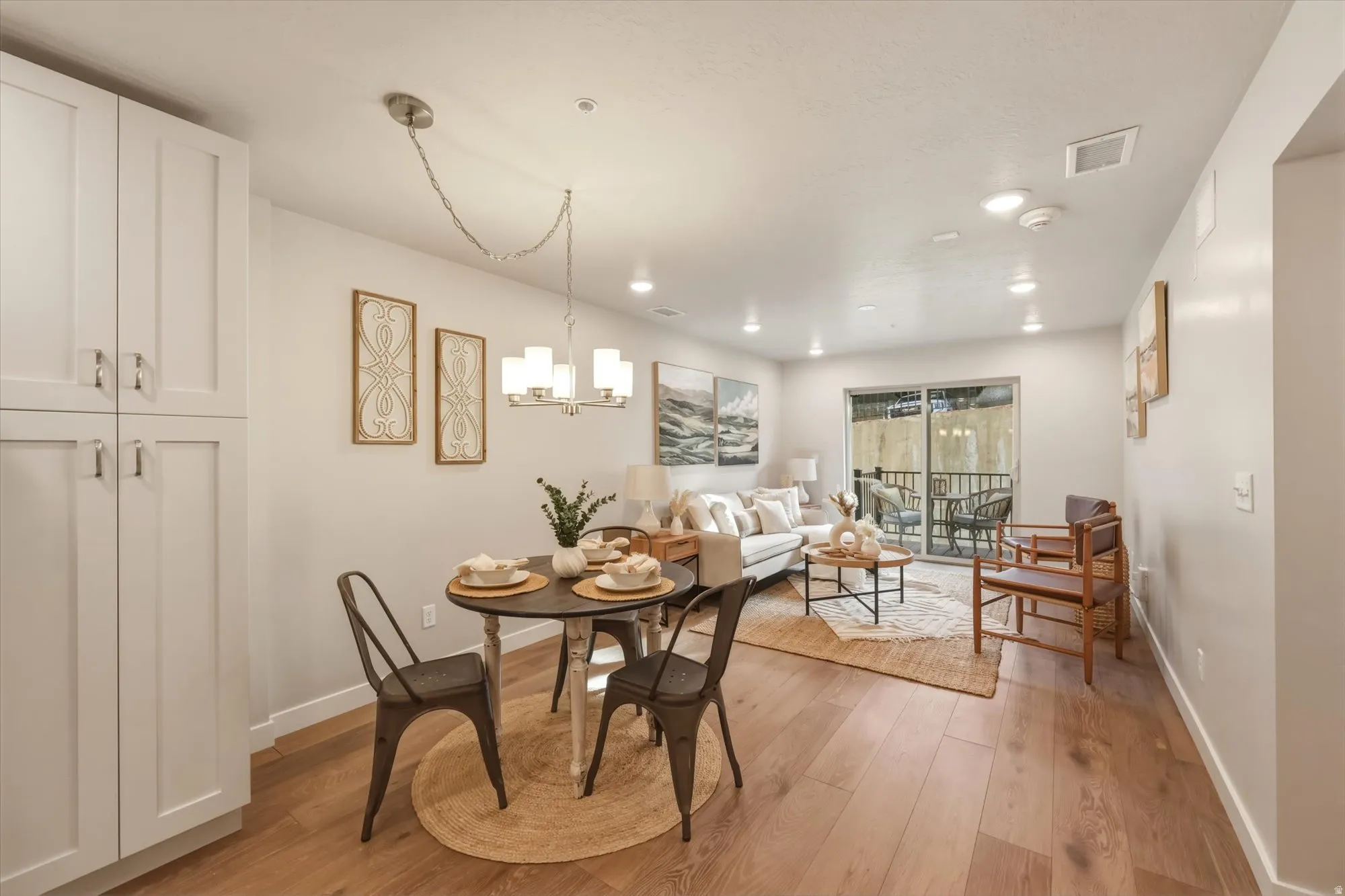 Dining room with light wood-style flooring and suspended lighting