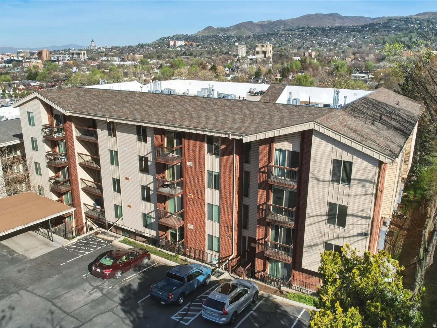 View of apartment building / complex featuring a mountain view and uncovered parking