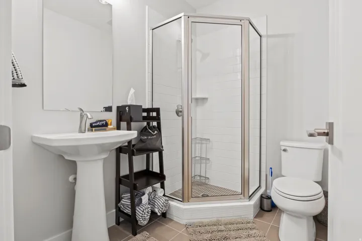 Full bath featuring light tile patterned floors and a shower stall