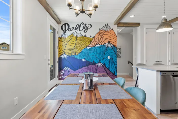 Dining room featuring beamed ceiling, light wood-style flooring, and hanging lights