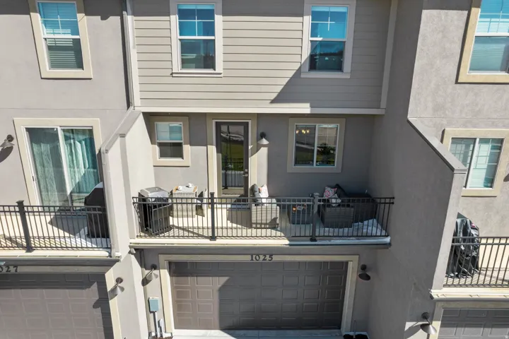 Back of house with a balcony, a garage, and stucco siding