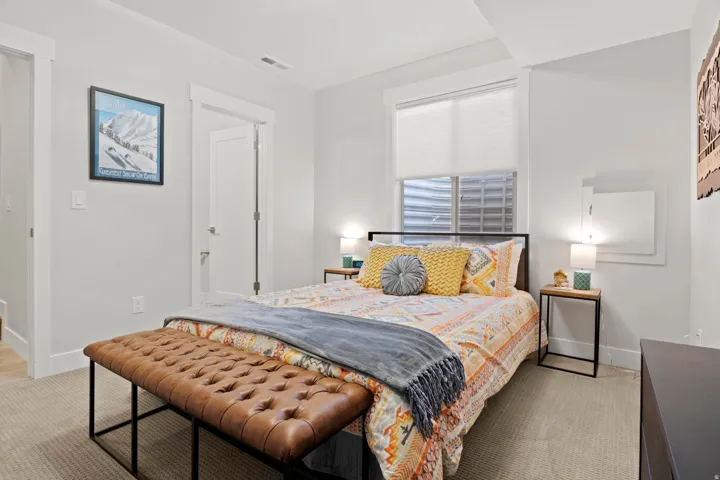 Bedroom with baseboards and light colored carpet