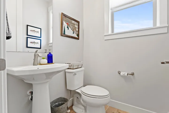 Half bath with toilet and light wood finished floors