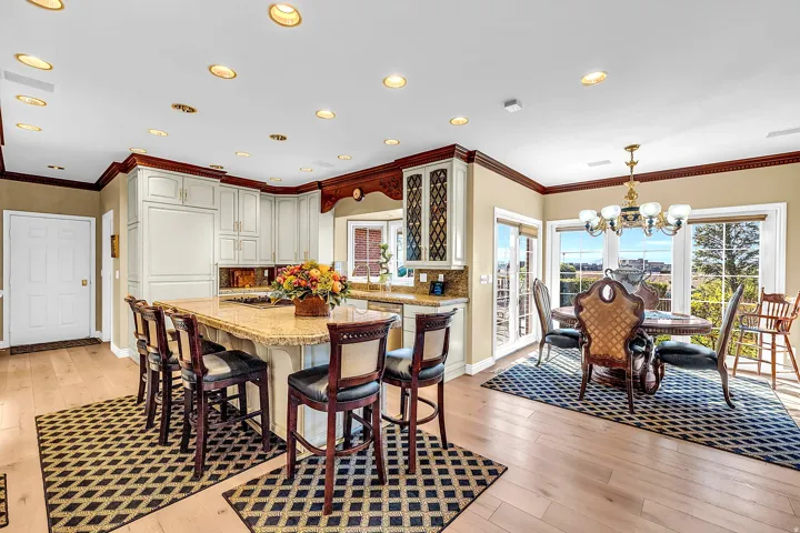 Dining room featuring light wood finished floors, suspended lighting, and ornamental molding