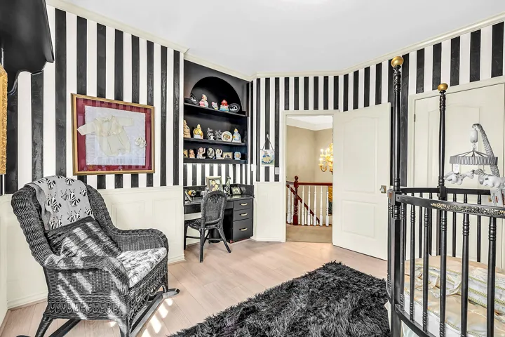 Bedroom featuring wainscoting, built in study area, wallpapered walls, light wood-style floors, and hanging lights