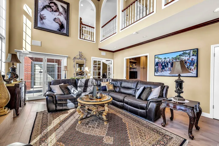 Living area featuring hardwood / wood-style flooring, a high ceiling, and ornamental molding