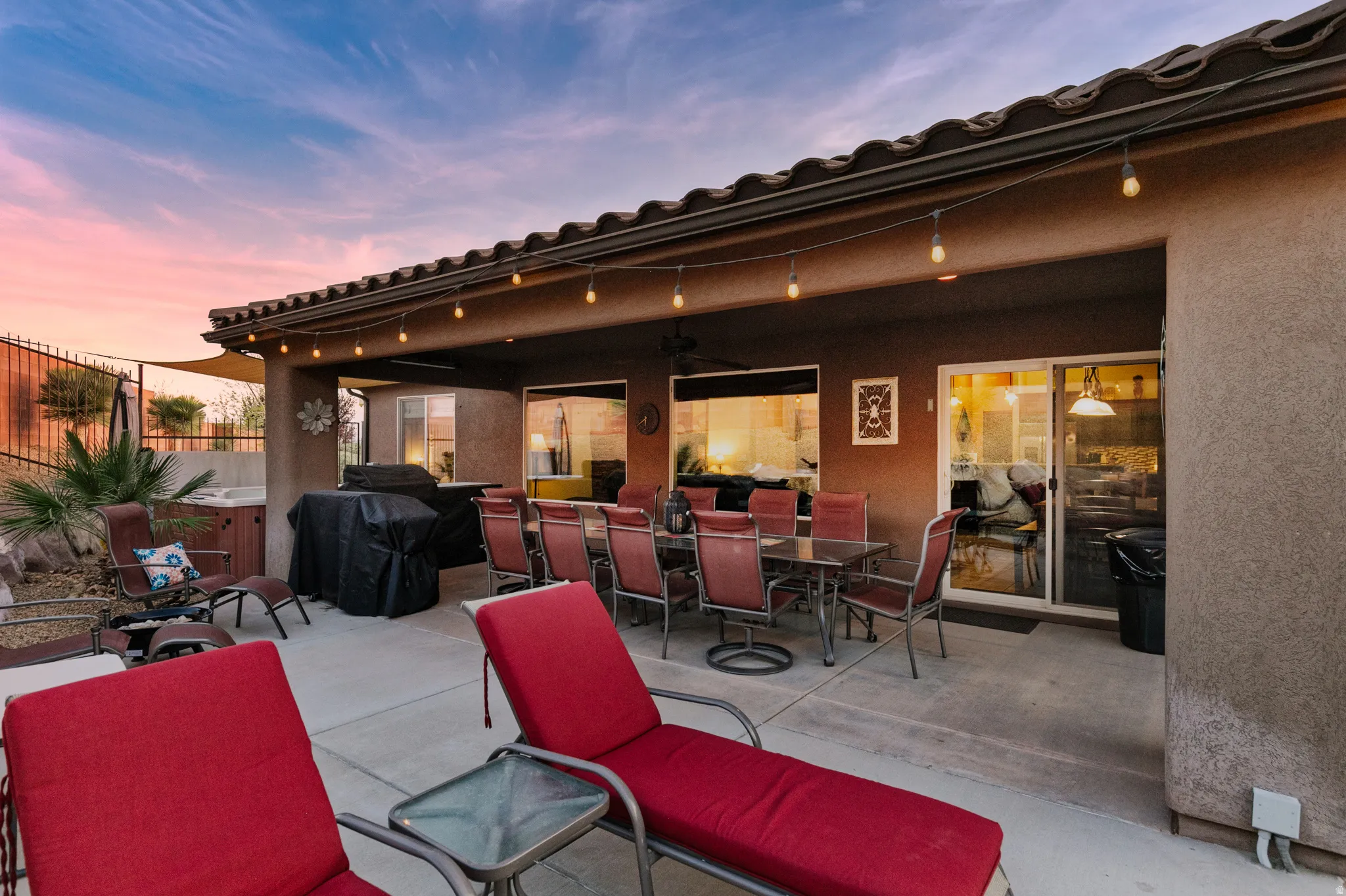 Patio terrace at dusk featuring a patio area, a ceiling fan, outdoor dining area, and grilling area