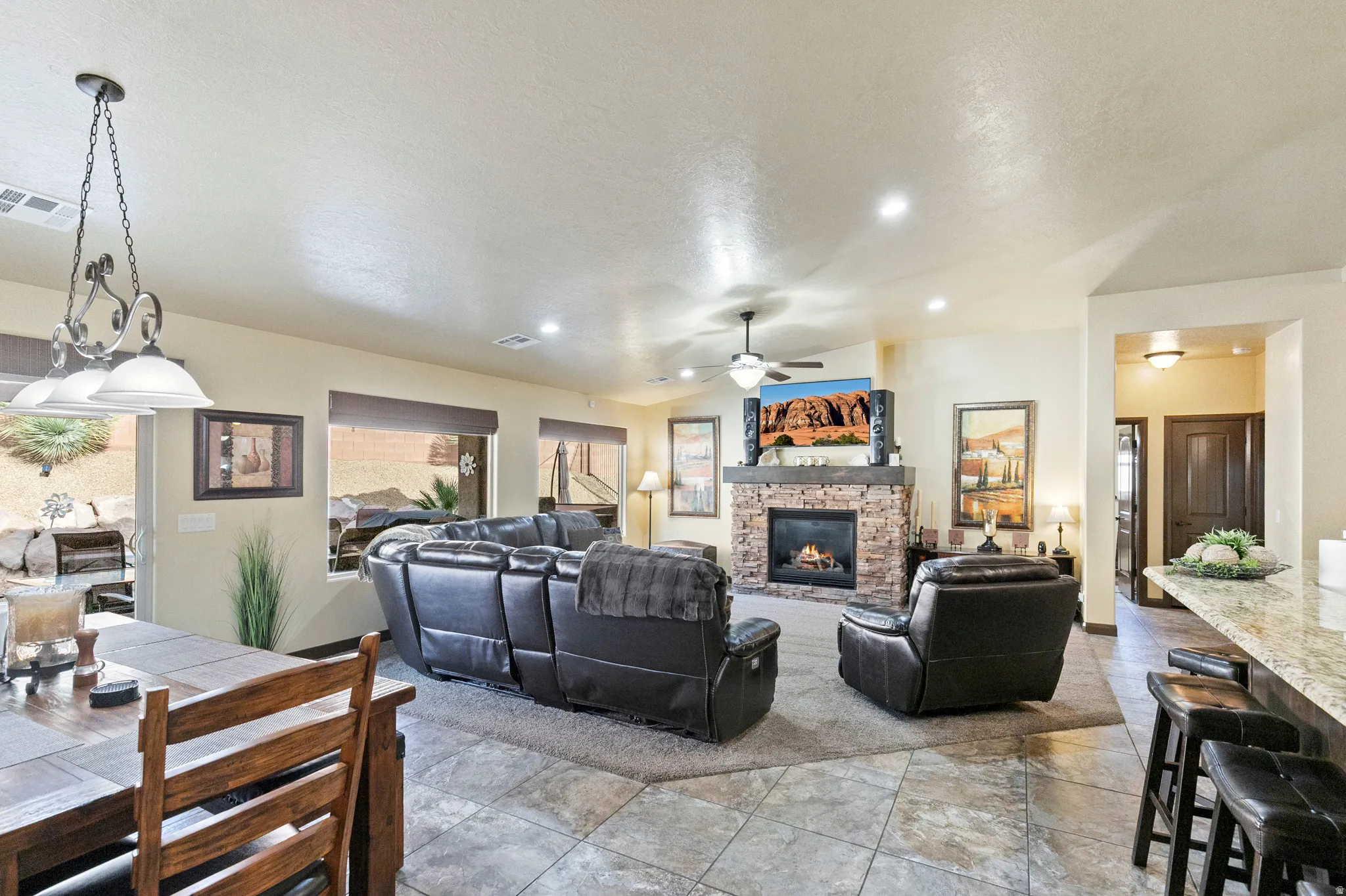 Living room featuring a fireplace, ceiling fan, and recessed lighting