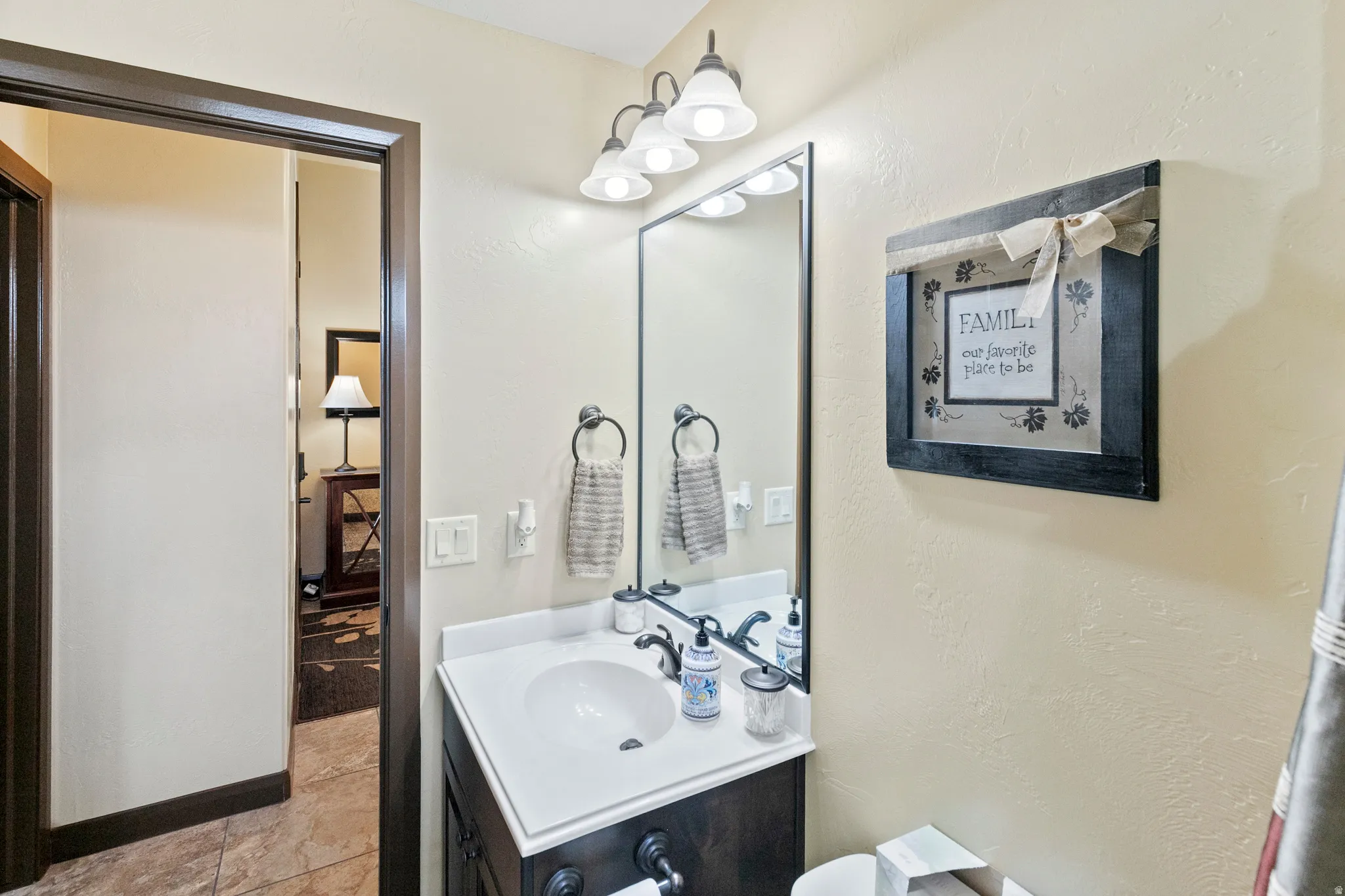 Half bath with vanity and a textured wall