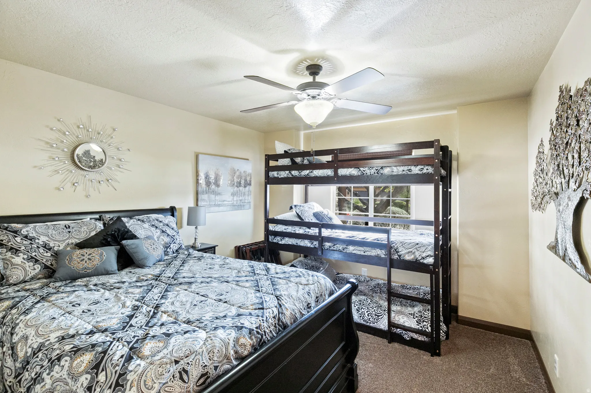 Bedroom with dark carpet, a ceiling fan, and a textured ceiling