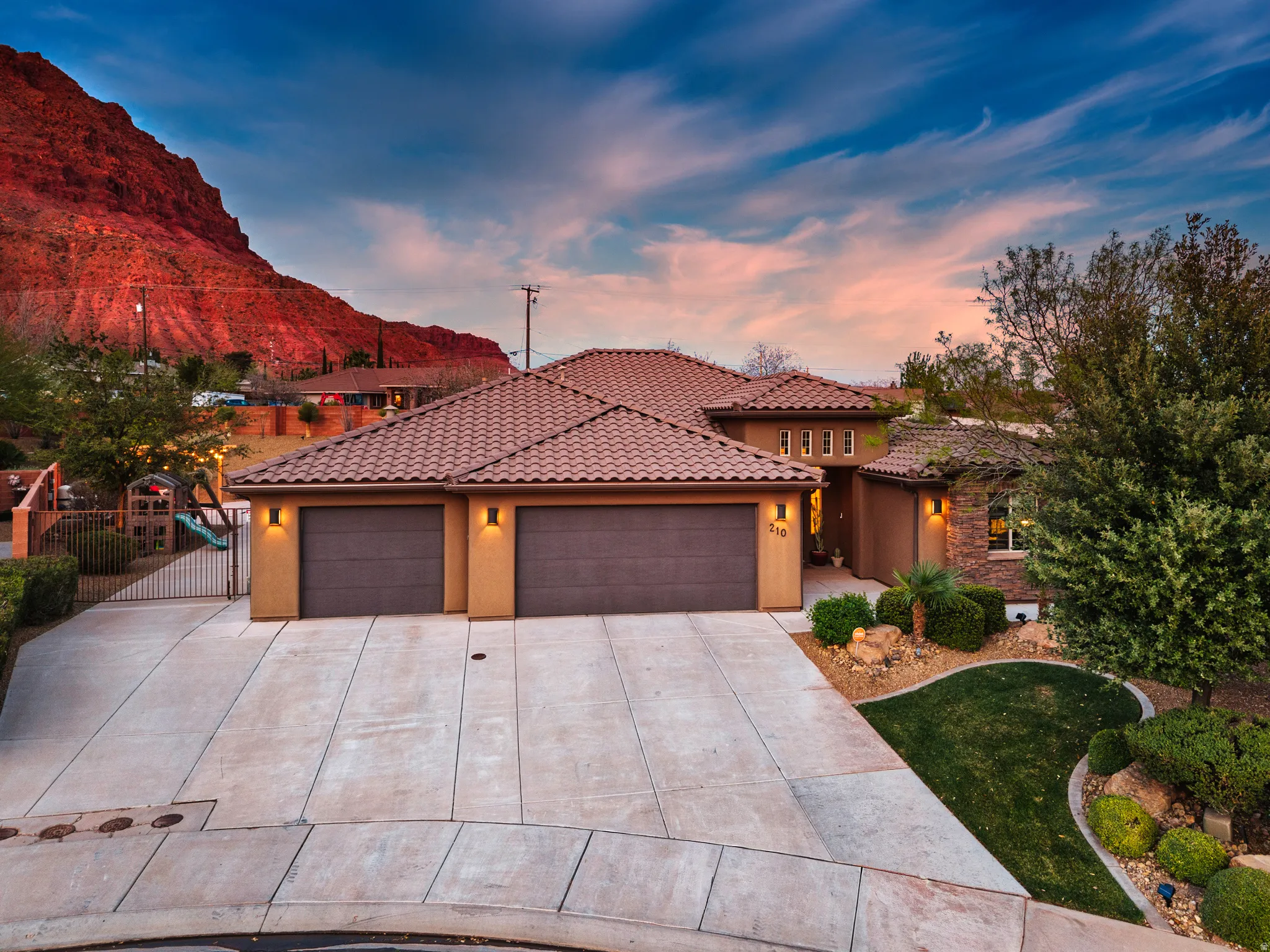 Mediterranean / spanish-style house featuring a garage, stucco siding, driveway, and a tiled roof