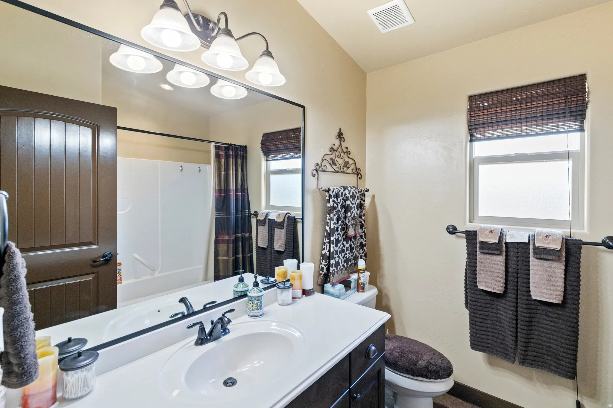 Full bathroom featuring vanity and hanging lights
