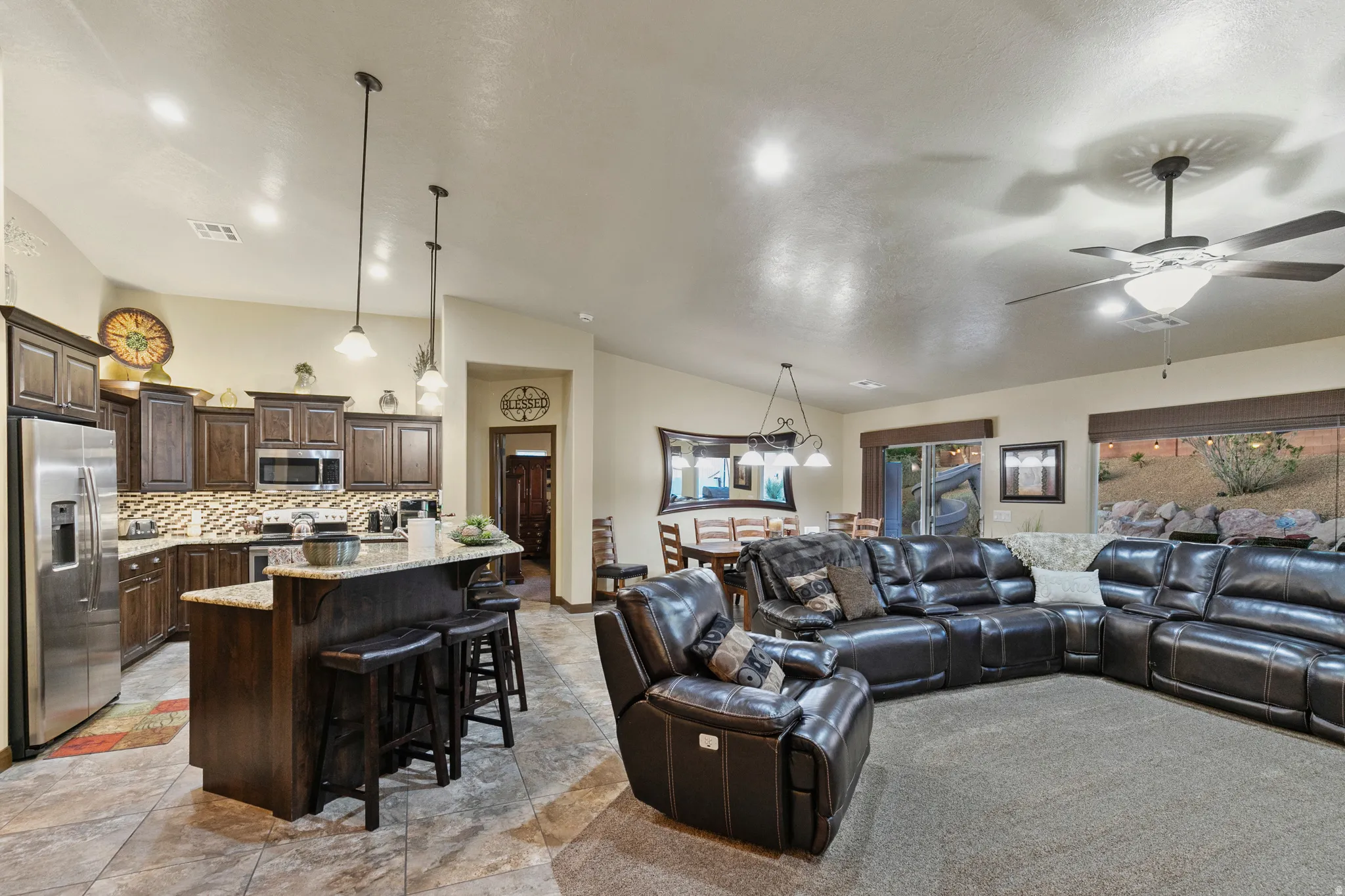 Living area featuring lofted ceiling, ceiling fan, and recessed lighting