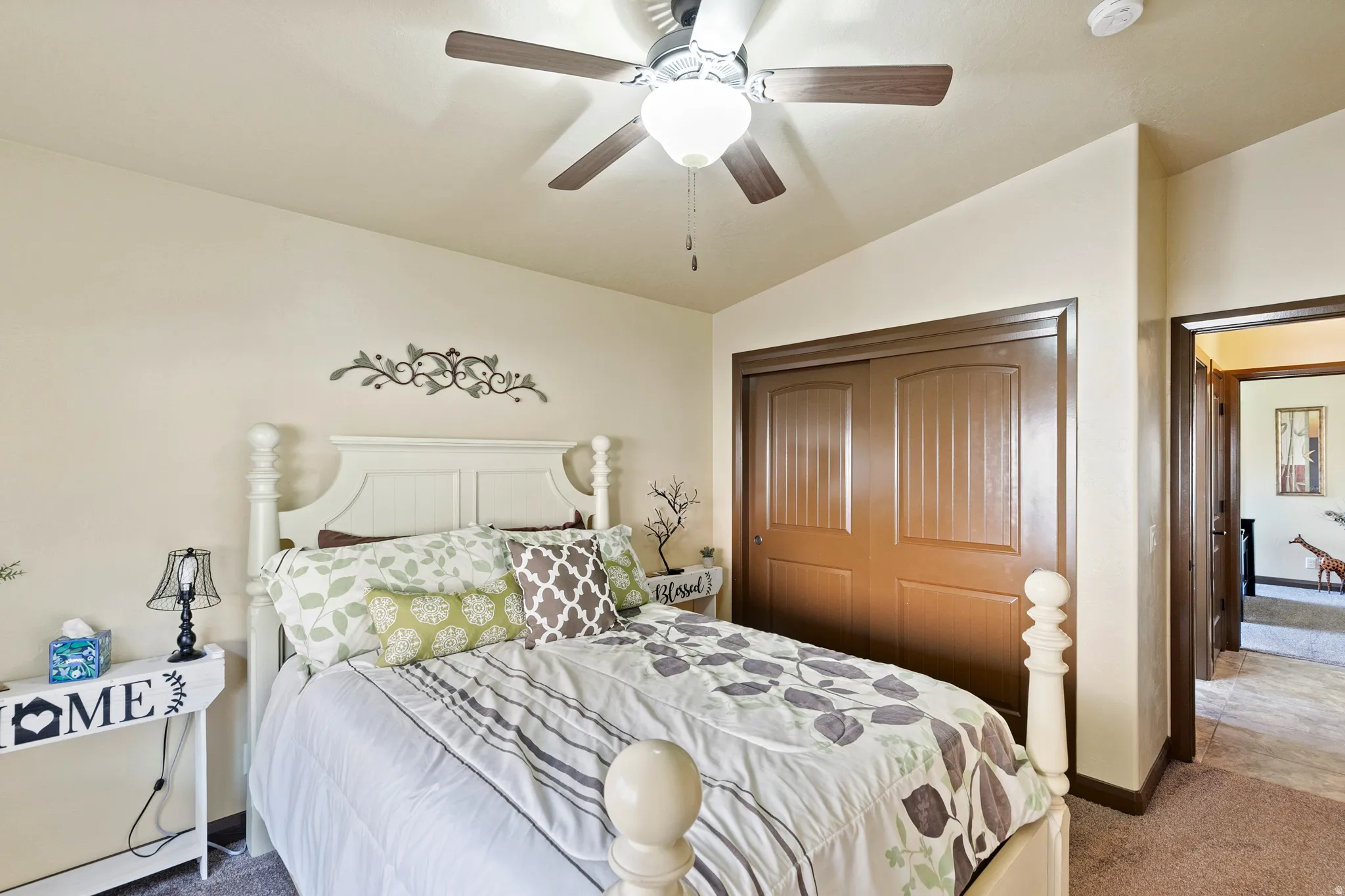 Bedroom featuring dark carpet, lofted ceiling, a closet, and a ceiling fan