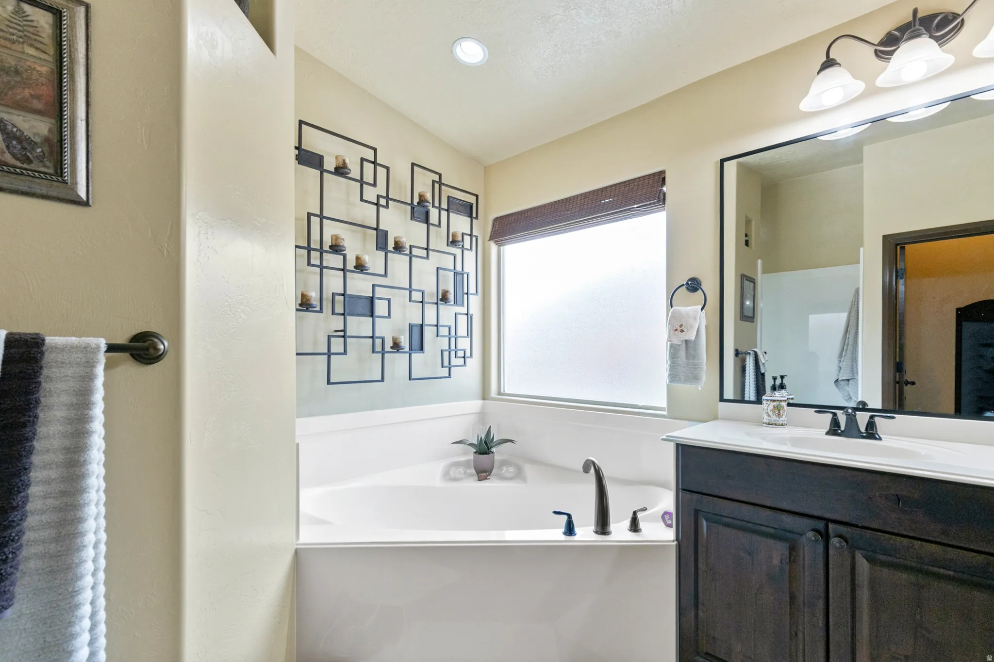 Bathroom with a bath, vanity, and recessed lighting
