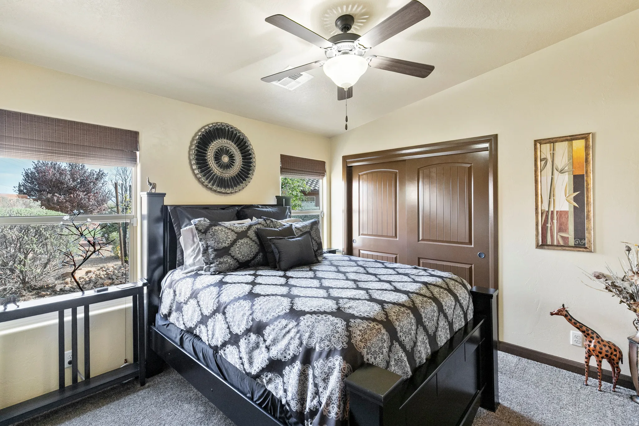 Bedroom with a closet, lofted ceiling, ceiling fan, and dark carpet