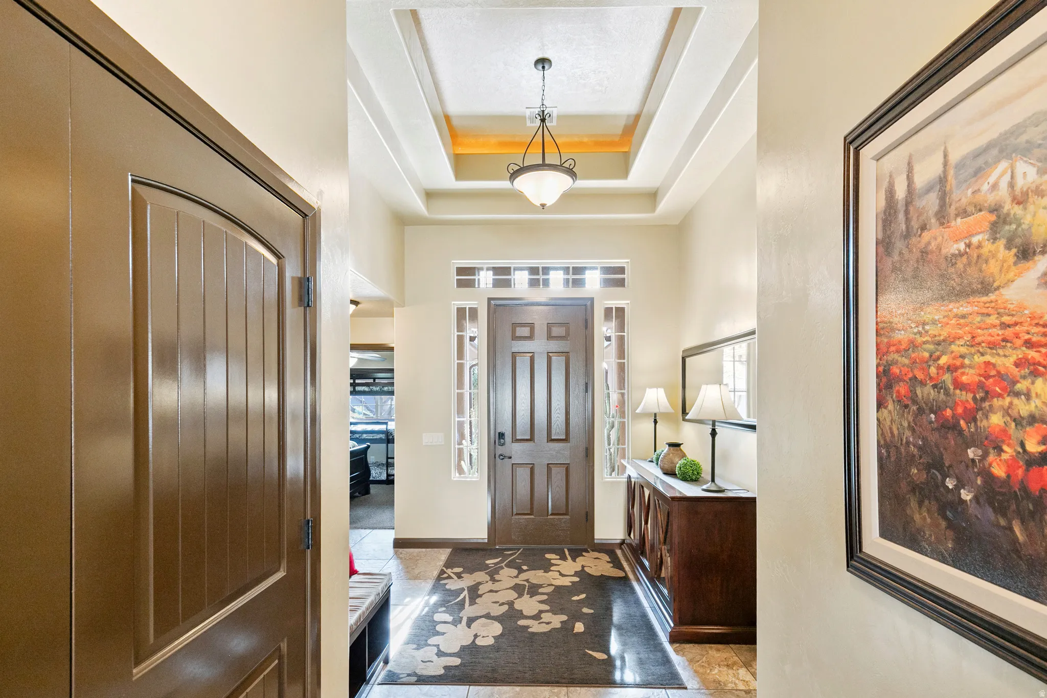 Foyer with a tray ceiling and healthy amount of natural light
