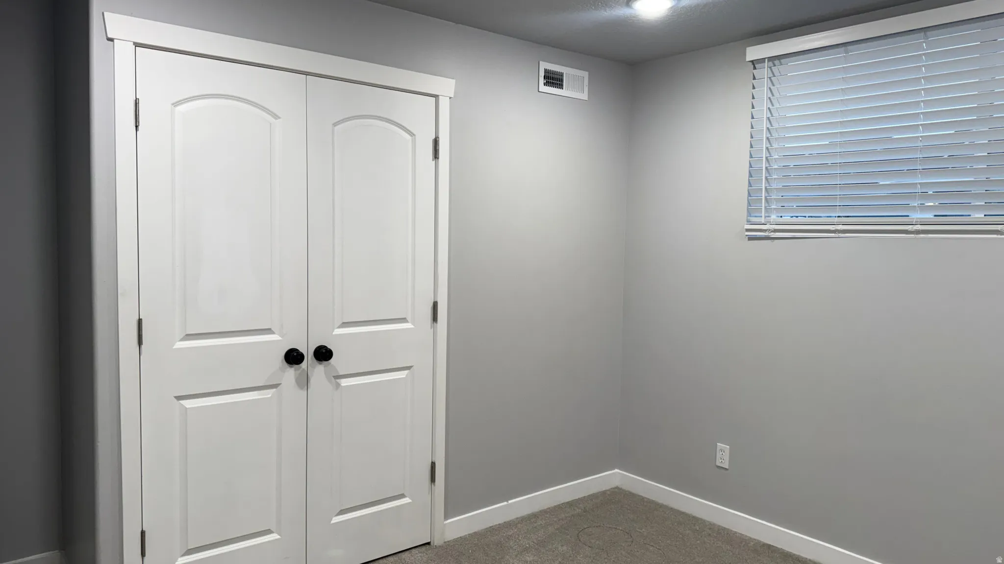 Unfurnished bedroom with dark carpet and a closet