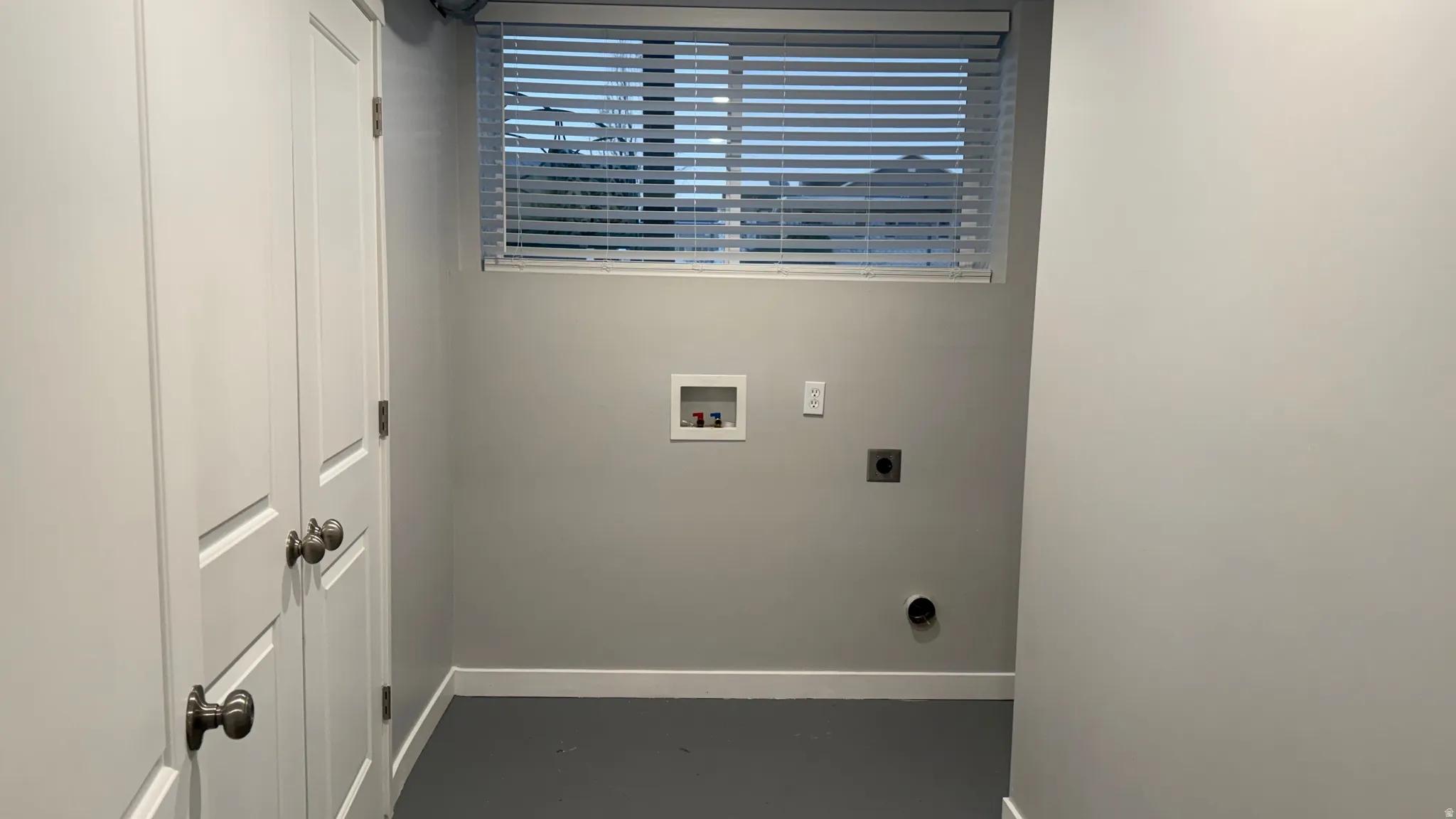 Laundry area with electric dryer hookup, hookup for a washing machine, and finished concrete floors