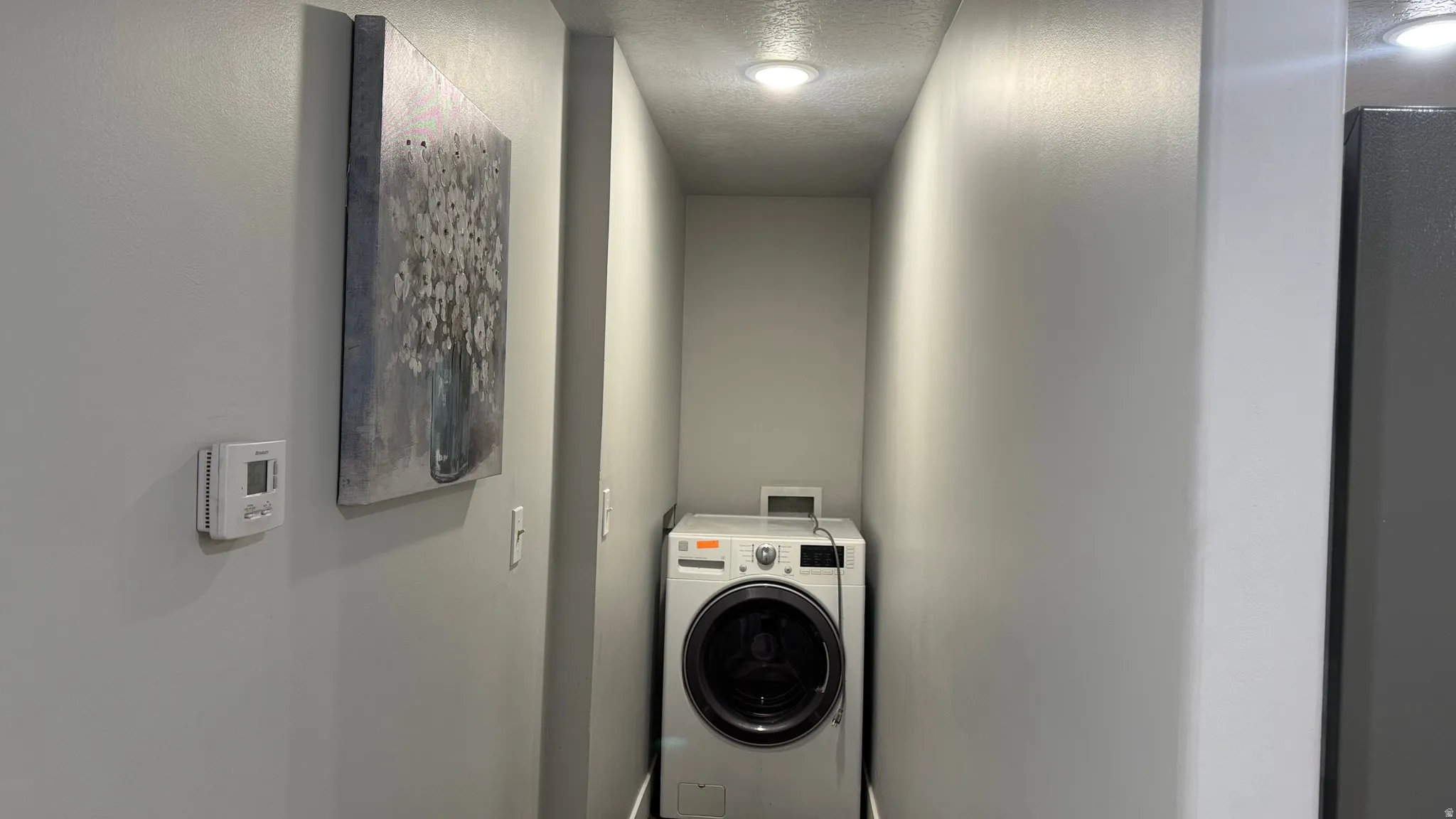 Laundry area featuring washer / dryer and a textured ceiling