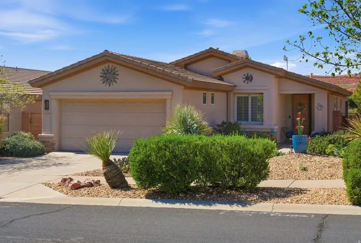View of front of home featuring a garage, driveway, stucco siding, and a tiled roof