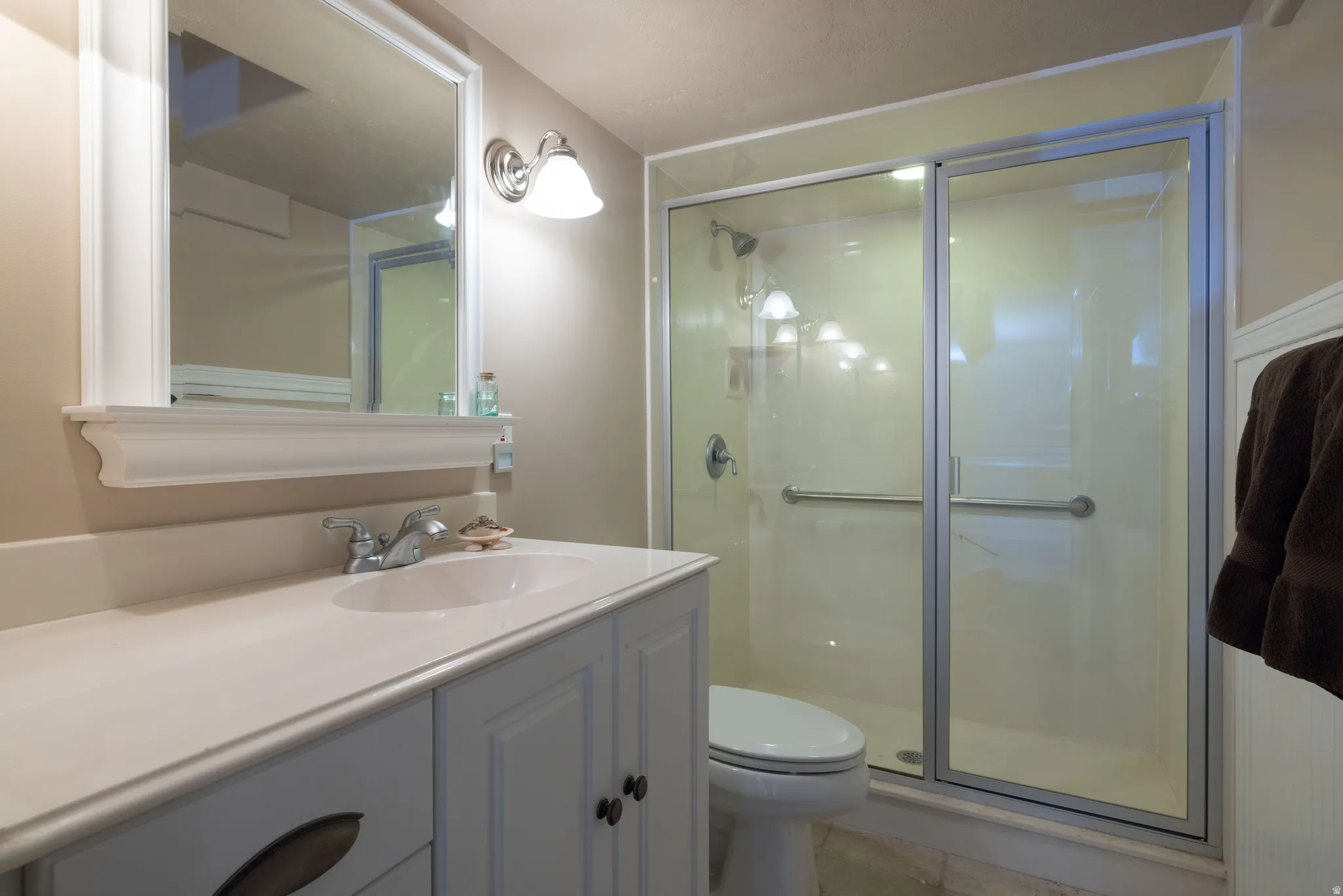 Full bathroom with vanity and a shower stall