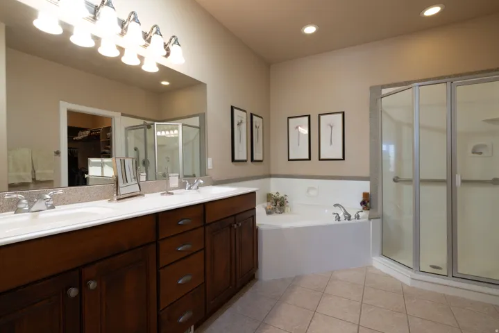 Master Bathroom with a shower stall, double vanity, a bath