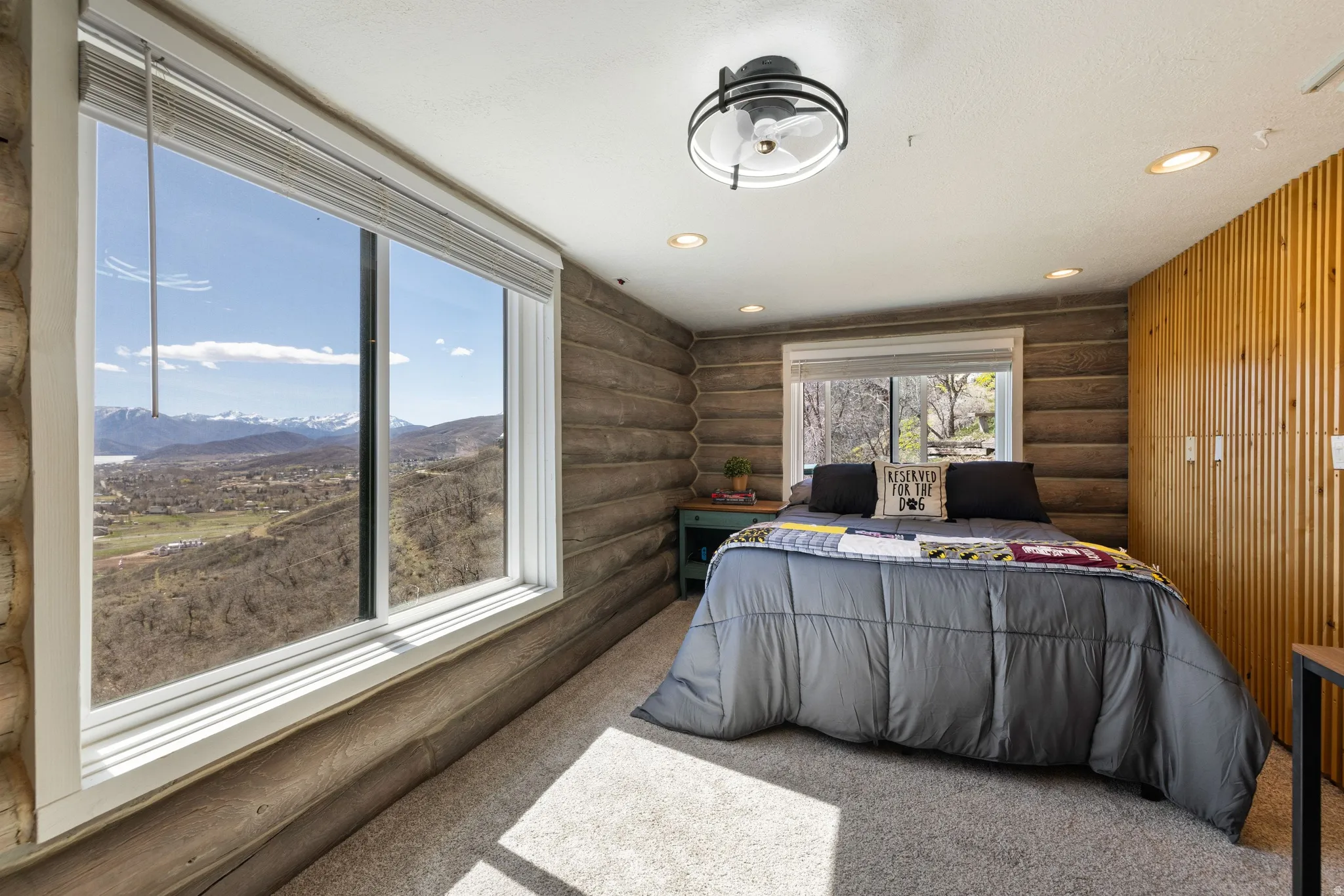 Bedroom with log walls, recessed lighting, light colored carpet, and a mountain view